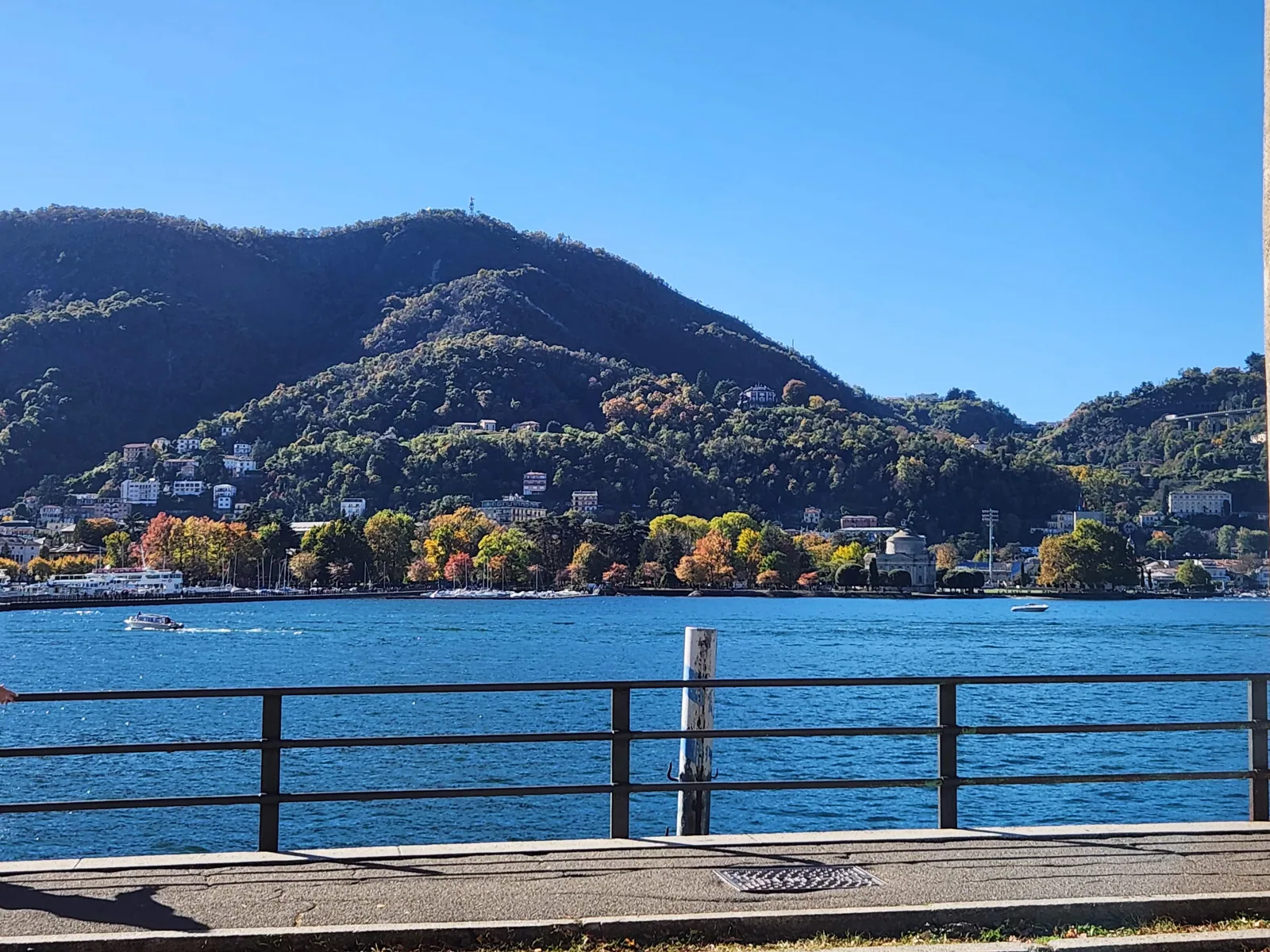 Lake Como waterfront in Como town with mountains across the water