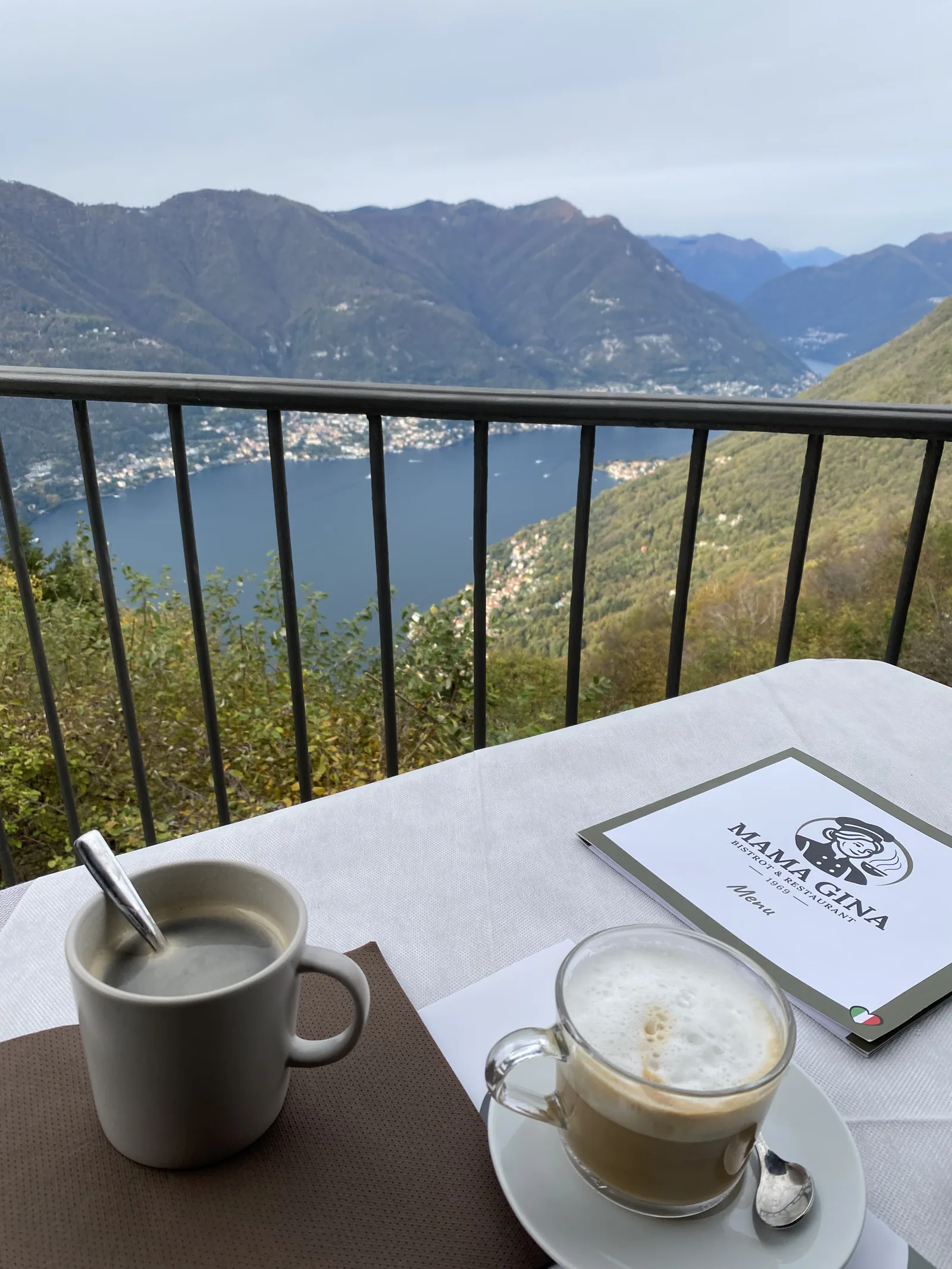 A latte on a terrace with a view of Lake Como and the mountains