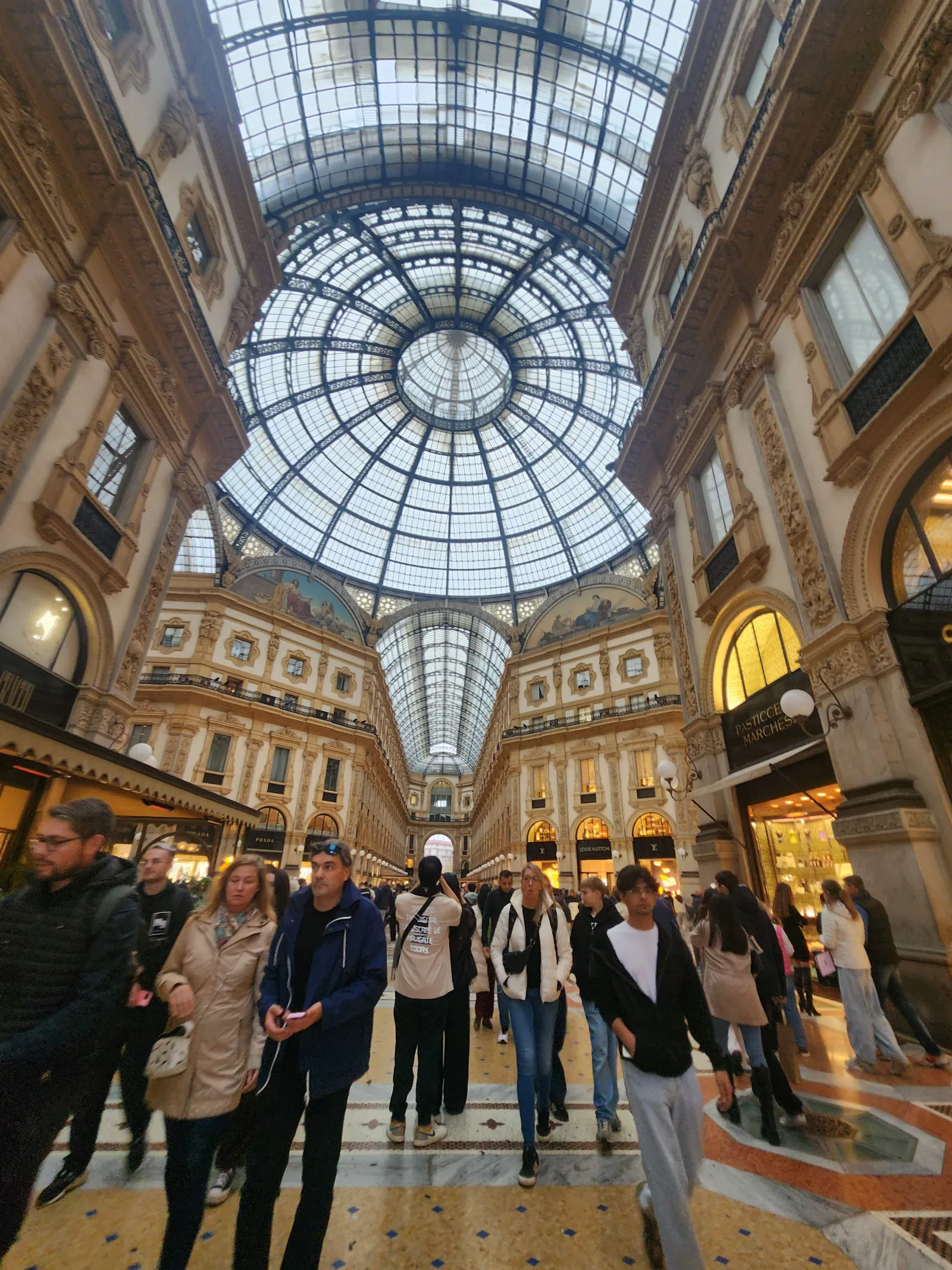 The interior arcade of the Galleria in Milan with shops and shoppers