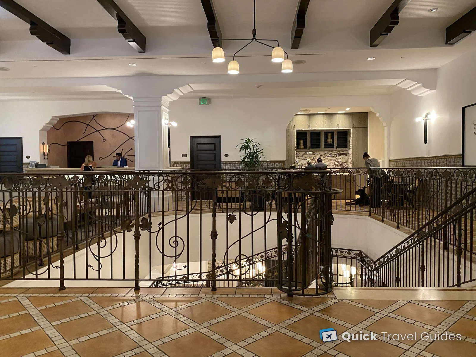 The Kimpton Canary lobby in Santa Barbara, with a wrought-iron staircase railing and Spanish tile floor