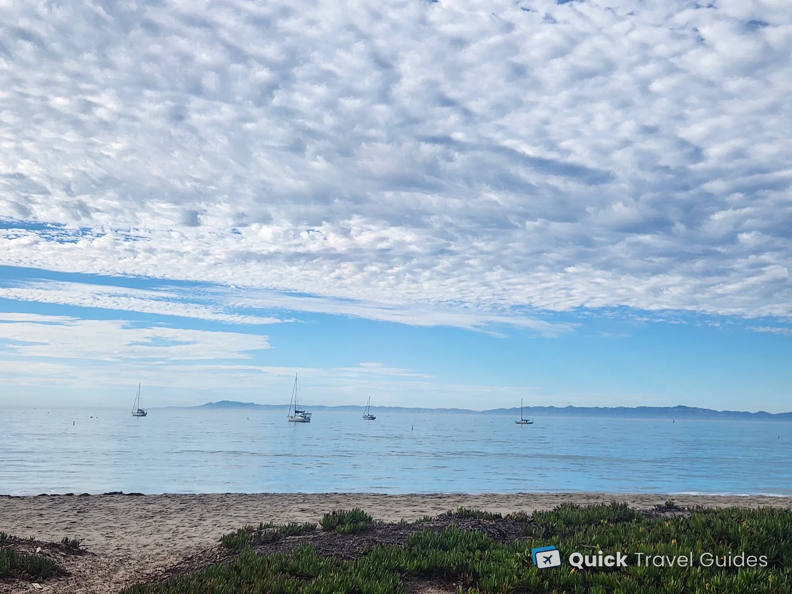 Sailboats anchored off the beach in Santa Barbara, with the Channel Islands on the horizon